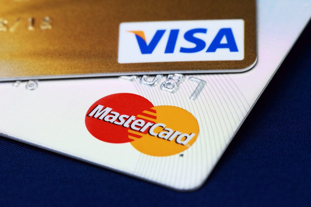 Kreditkarten von Mastercard und Visa vor blauem Hintergrund, Kreditkarte akzeptieren